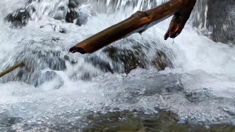 an einem warmen frühlingstag stürzt wasser über moosbedeckte felsen in einem gebirgsbach