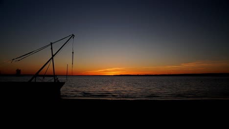 Zeitraffer-Eines-Wunderschönen-Sonnenuntergangs-Mit-Der-Silhouette-Eines-Bootes-Am-Britannia-Beach,-Ottawa