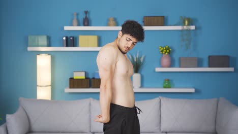 athlete young man exercising, looking at his body, arm muscle. muscular body.