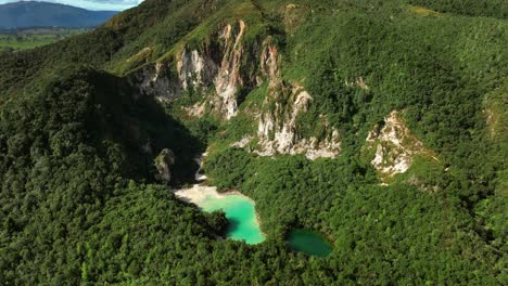 rainbow mountain cliffs with crater lakes in lush green forest of new zealand