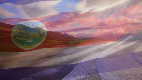 Digital-composition-of-waving-costa-rica-flag-against-aerial-view-of-the-beach