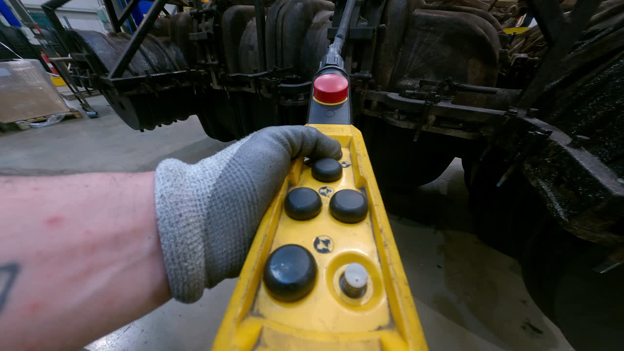 el trabajador presiona el botón de un comando industrial para levantar un molde de metal y dejar que caiga y se retuerza libremente, punto de vista original