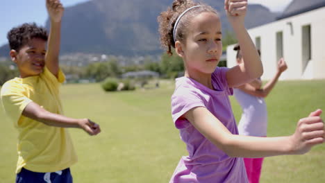 biracial girl in a purple shirt practices martial arts outdoors in school, flanked by two children