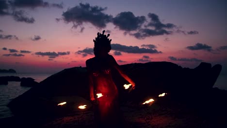 sexy and erotic belly dancer, performing spinning and figure 8 moves with fire palm torch props, on the beach during golden hour.
