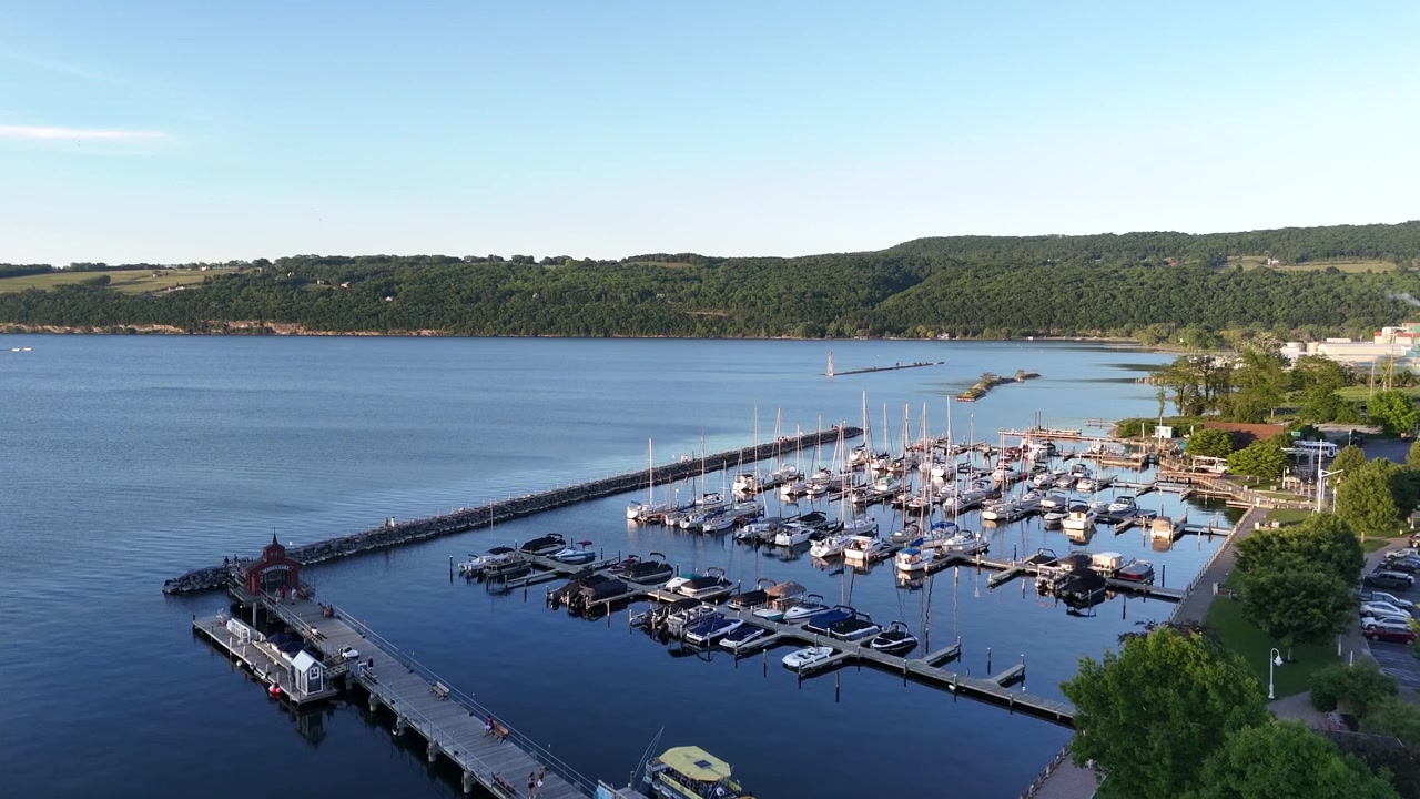 New York'un Finger Lakes bölgesindeki Watkins Glen'de bulunan Seneca Gölü'nün drone çekimi. Limanın, marina iskelelerinin ve doğal sahil şeridi boyunca demirlemiş teknelerin görünümü.