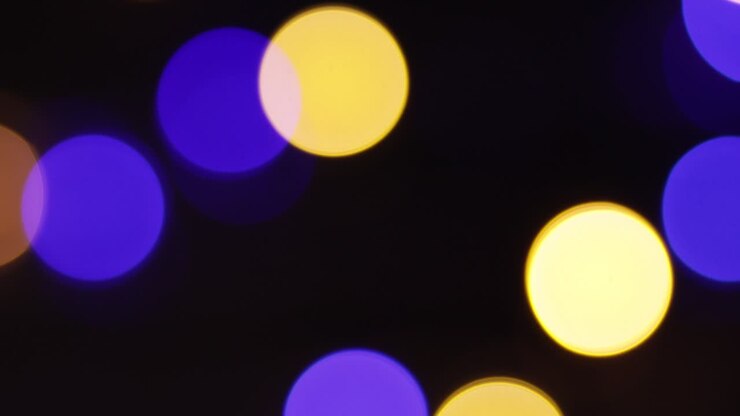 Sfondo natalizio sfocato. Video di luci natalizie sfocate con cerchi colorati scintillanti. Filmato 4K di effetti di luce multicolori su sfondo nero. Felice Anno Nuovo