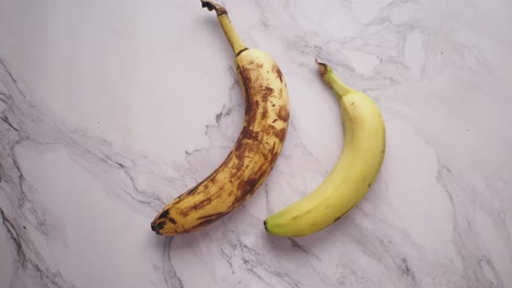 two bananas on a marble surface