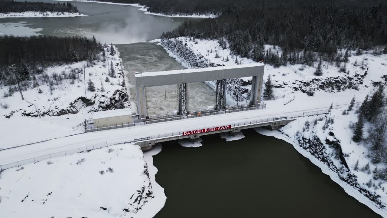 Aerial Slow Orbit Drone Shot Rushing Water Notigi Hydroelectric Power Lake Dam in Snowy Northern Winter Manitoba Canada