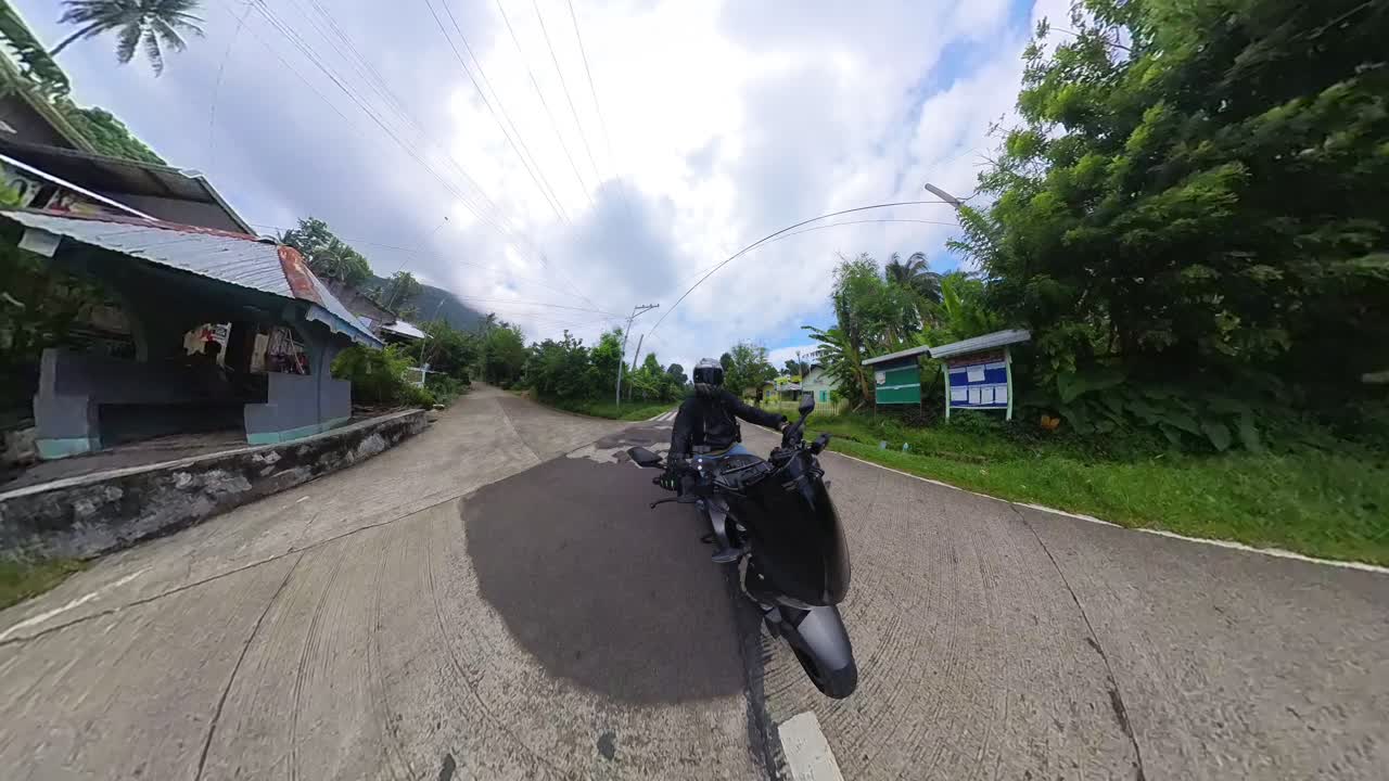 Point of view fisheye footage of a sports bike rider cruising through the rural landscapes of Panaon Island, Philippines.