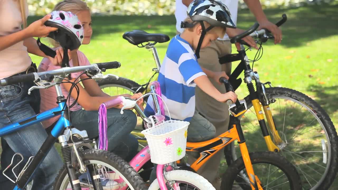 두 자녀 가 부모 와 함께 자전거 를 타고 있다