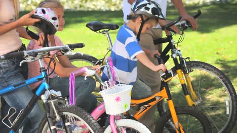dos niños en bicicleta con sus padres