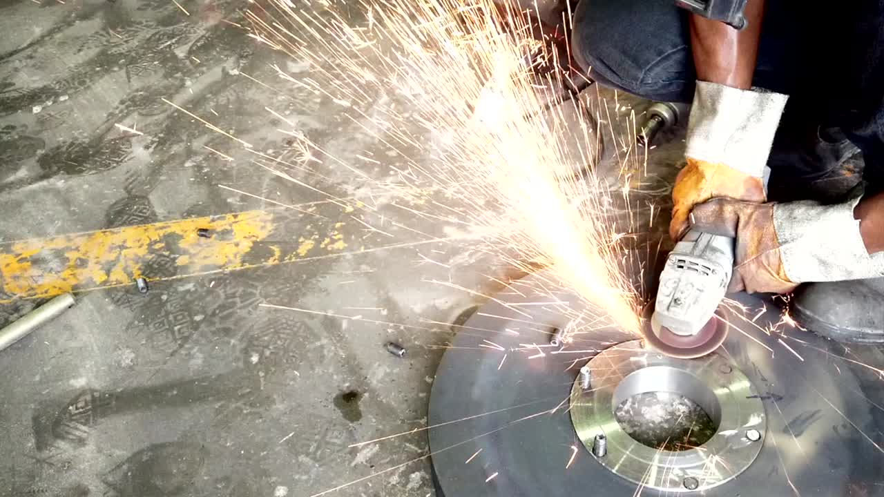trabajador moliendo y cortando placa de acero con mucha chispa
