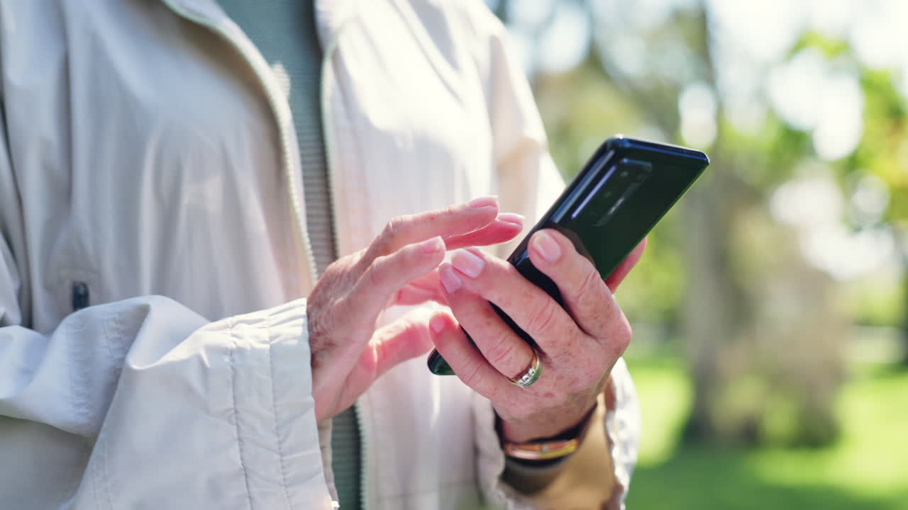전화 를 들고 공원 에 있는 고위 여성
