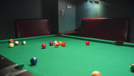 billiard balls scattered across green pool table after powerful break shot, vibrant colored balls, intense motion, blurred action, pool game aftermath, excitement, high-energy sports moment