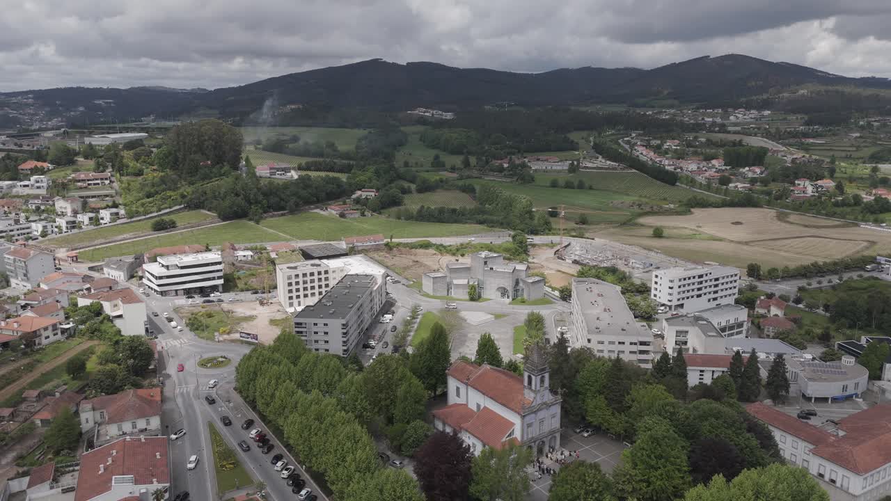 aerial - main church and town center surrounded by hills in Lousada Portugal under cloudy sky