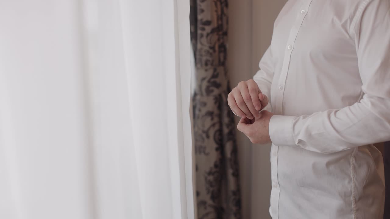 Sposo che si prepara in camicia bianca