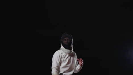 young male fencer in white uniform with black mask