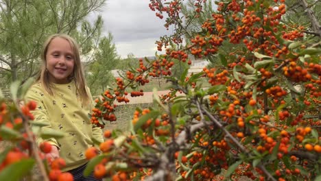 girl picking berries on a bush and throwing them