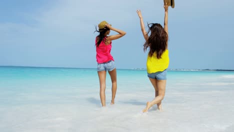 felices amigas multiétnicas en vacaciones en la playa del océano