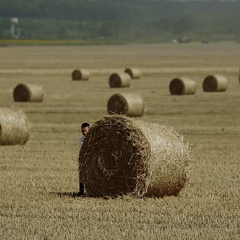 kind op een veld tegen stro