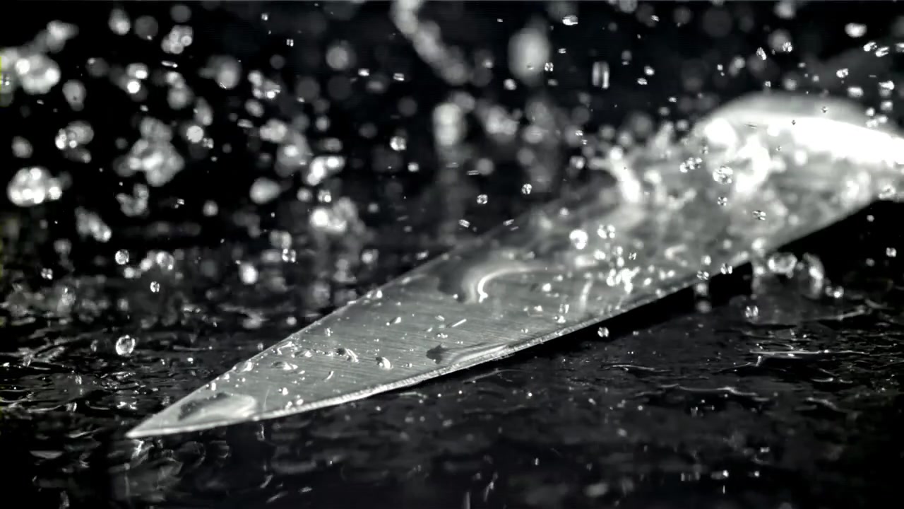 Water Drops Splashing on a Sharp Knife Blade in Slow Motion