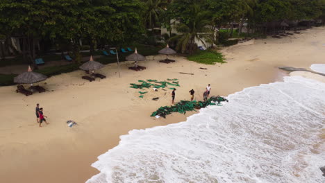 unrecognizable people sorting waste on beach