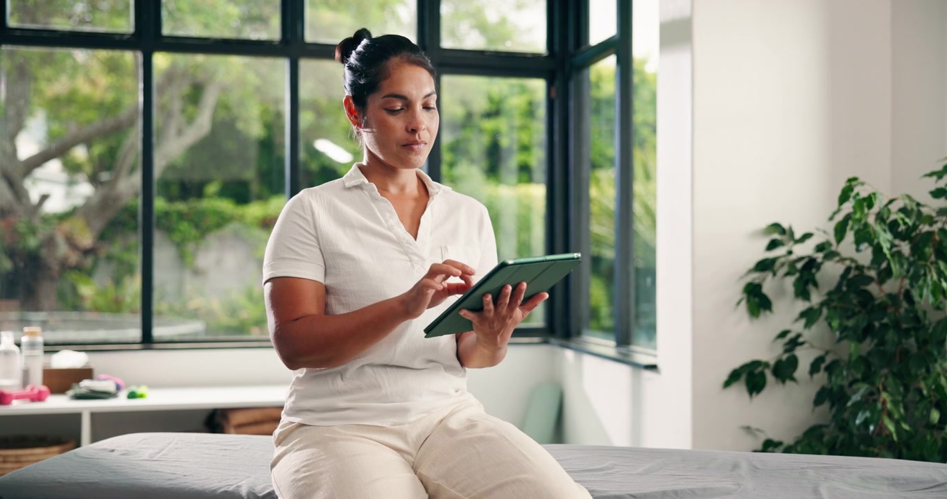 Female Physical Therapist Using Tablet in Clinic