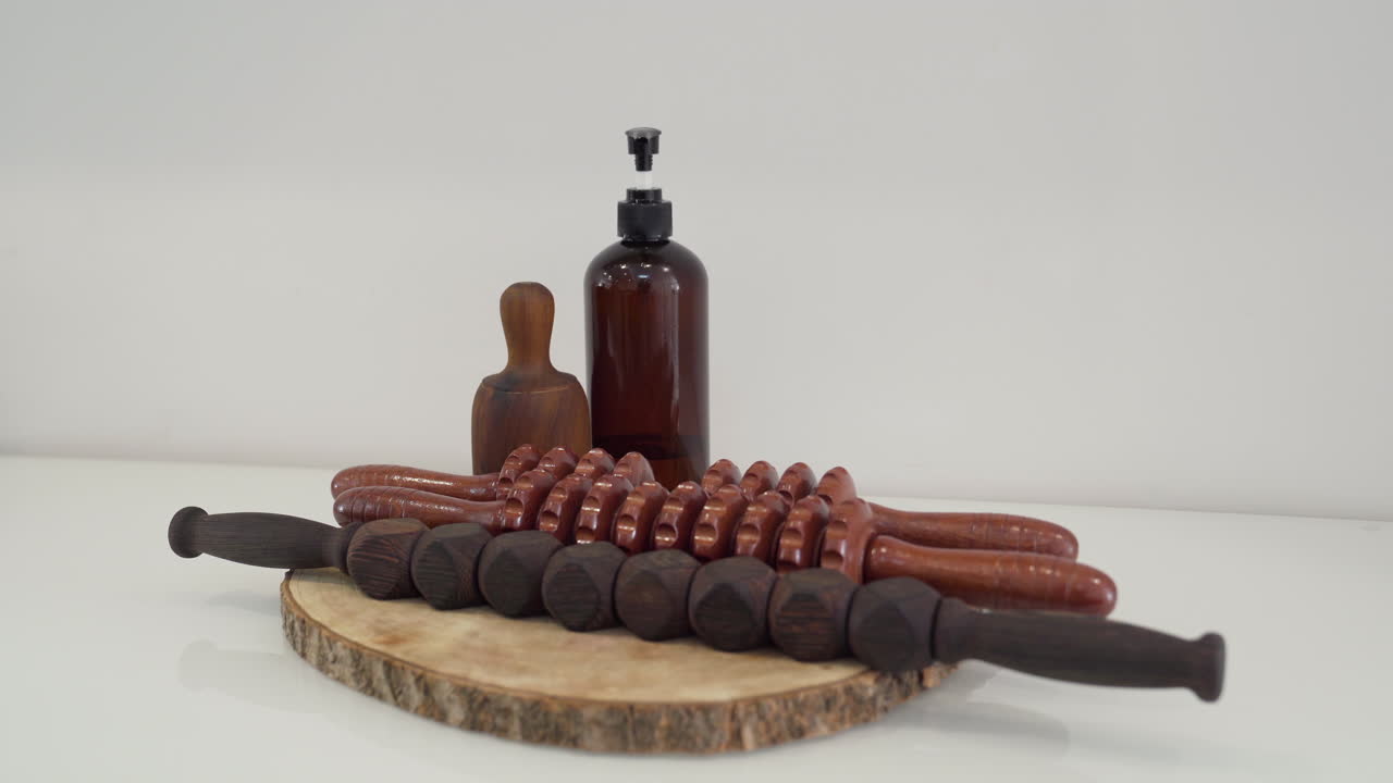 Set of wooden tools with different types of rollers, cup, paddles and oil for wood therapy