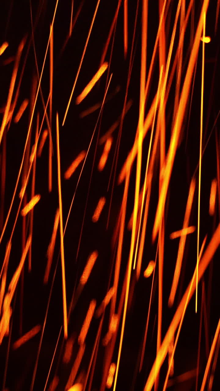 Long shining sparkles flying in changing direction. Beautiful bright scintilla moving quickly at black backdrop. Vertical video