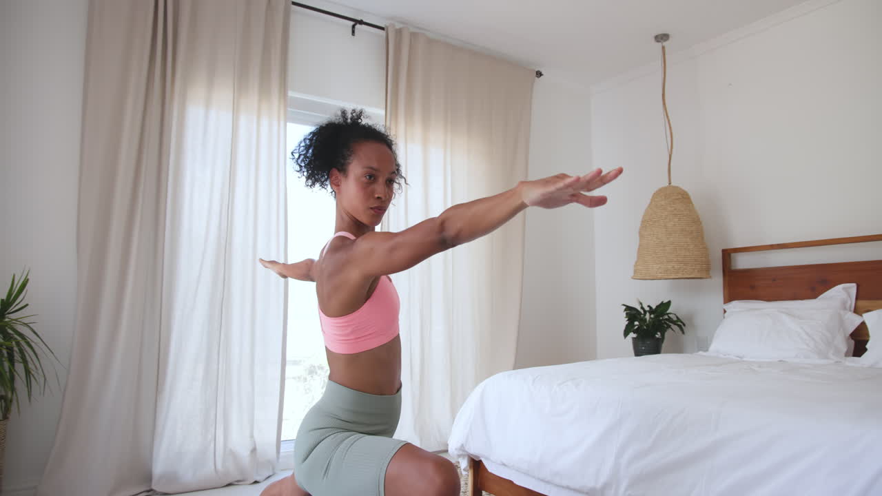 Donna che pratica yoga a casa, facendo stretching in una camera da letto luminosa