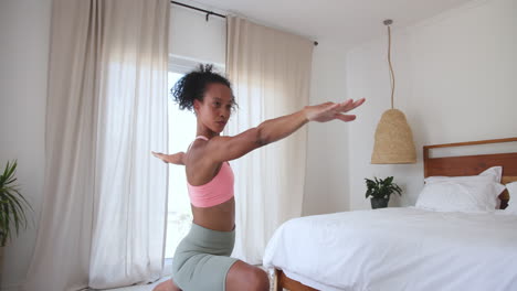woman practicing yoga at home, stretching in bright bedroom
