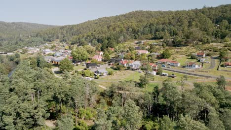 Ciudad-Turística-De-Tasmania-De-Derby-Toma-Aérea-Con-Casas-De-Vacaciones-Y-Bosques-En-Un-Día-Soleado,-Tasmania,-Australia