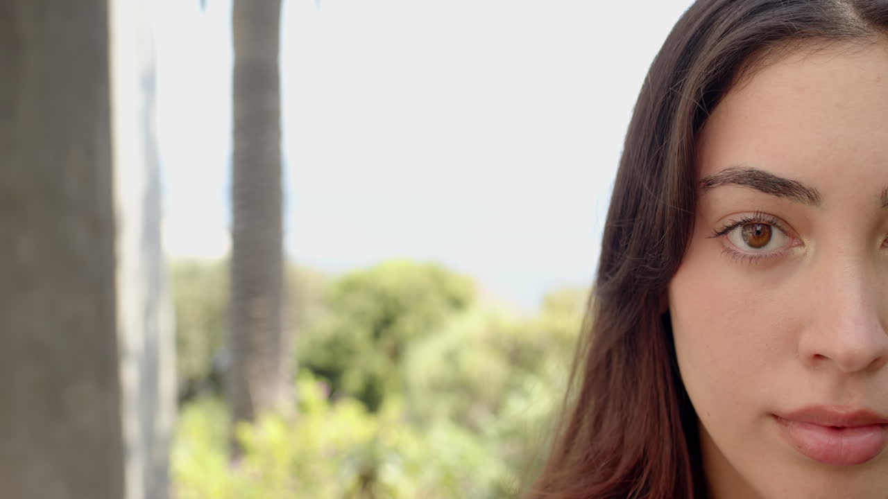 Gazing thoughtfully, woman surrounded by lush greenery in outdoor setting, copy space