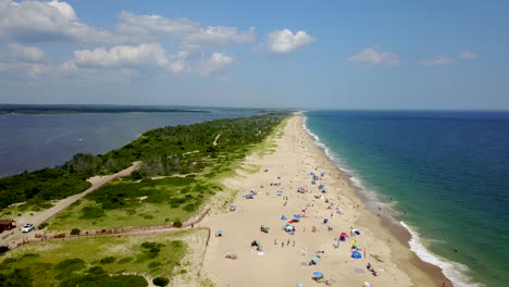 Drone-shot-moving-forward-of-Atlantic-Ocean-and-bay-with-shore-houses,-beach,-boats,-and-boardwalk