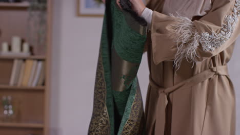 close up de una mujer musulmana en casa colocando una alfombra de oración en el suelo
