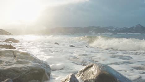 olas rompiendo en la costa rocosa durante la puesta de sol en noruega - primer plano