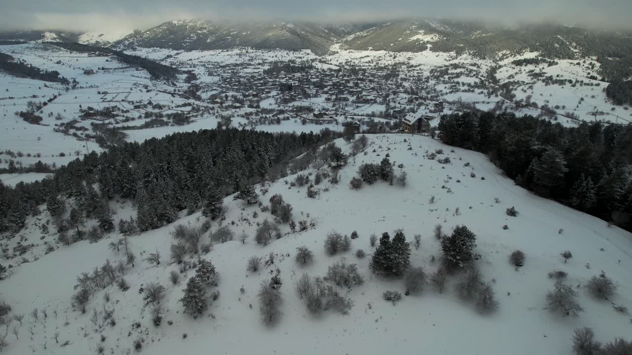 bella campagna in inverno con case di villaggio e foresta ricoperta di neve bianca a voskopoja, albania