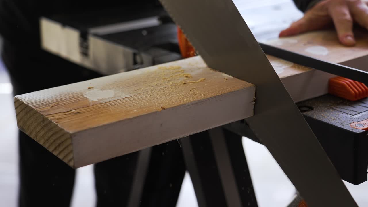 rotación en cámara lenta alrededor de un hombre que corta una pieza de madera