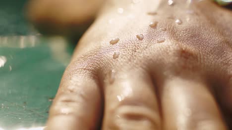 Mano-De-Mujer-Al-Costado-De-La-Piscina-Deslizándose-Lentamente-Hacia-El-Agua