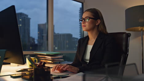 Tired-businesswoman-working-computer-at-night.-Focused-financial-analyst-check