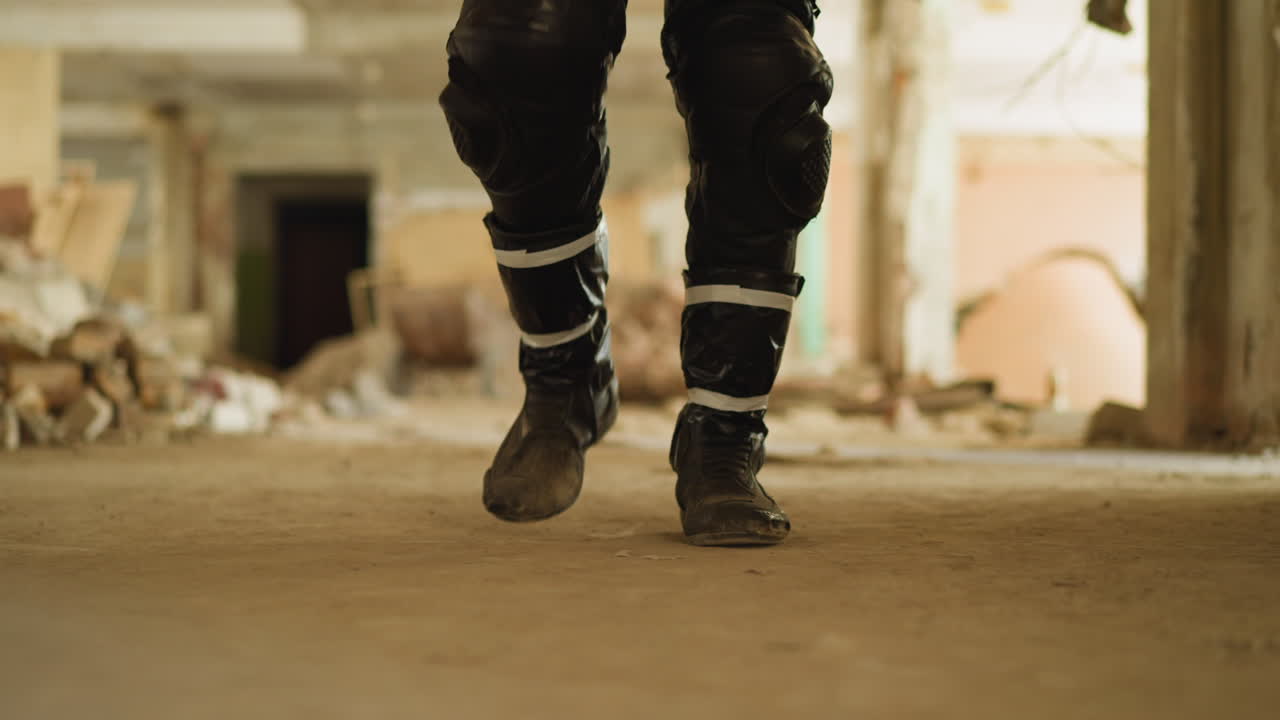 hombre con botas polvorientas camina por el pasillo de un edificio abandonado