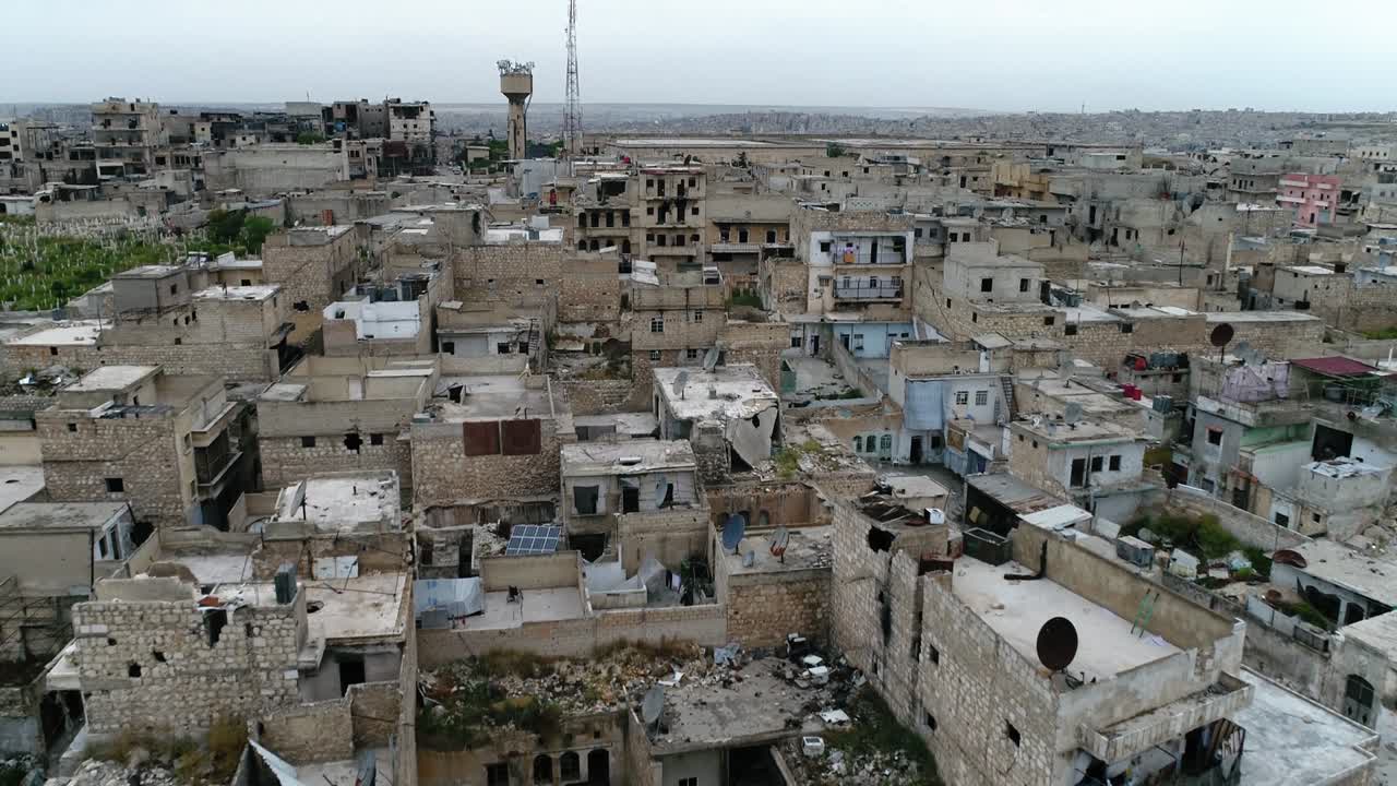 un dron volando sobre una ciudad siria. algunos de los edificios todavía están en ruinas después de la guerra civil hace 10 años - vista aérea 4k