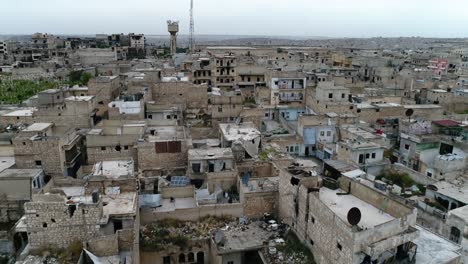 un dron volando sobre una ciudad siria. algunos de los edificios todavía están en ruinas después de la guerra civil hace 10 años - vista aérea 4k