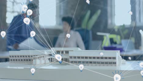 animation of lightbulb icons over diverse colleagues discussing with model in office