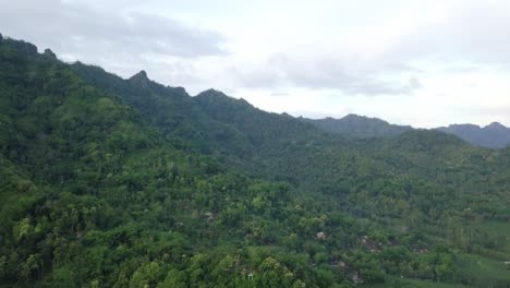 Luftflug-über-Malerische-Dichte-Waldbäume-Am-Menoreh-hügel-Mit-Campingplatz-In-Indonesien