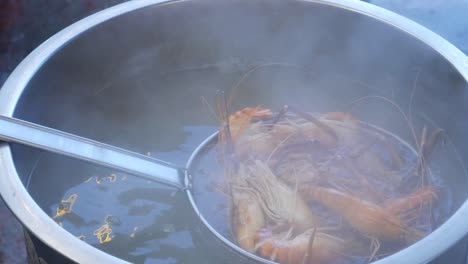 cocción de camarón de río fresco en agua caliente en una enorme olla de metal