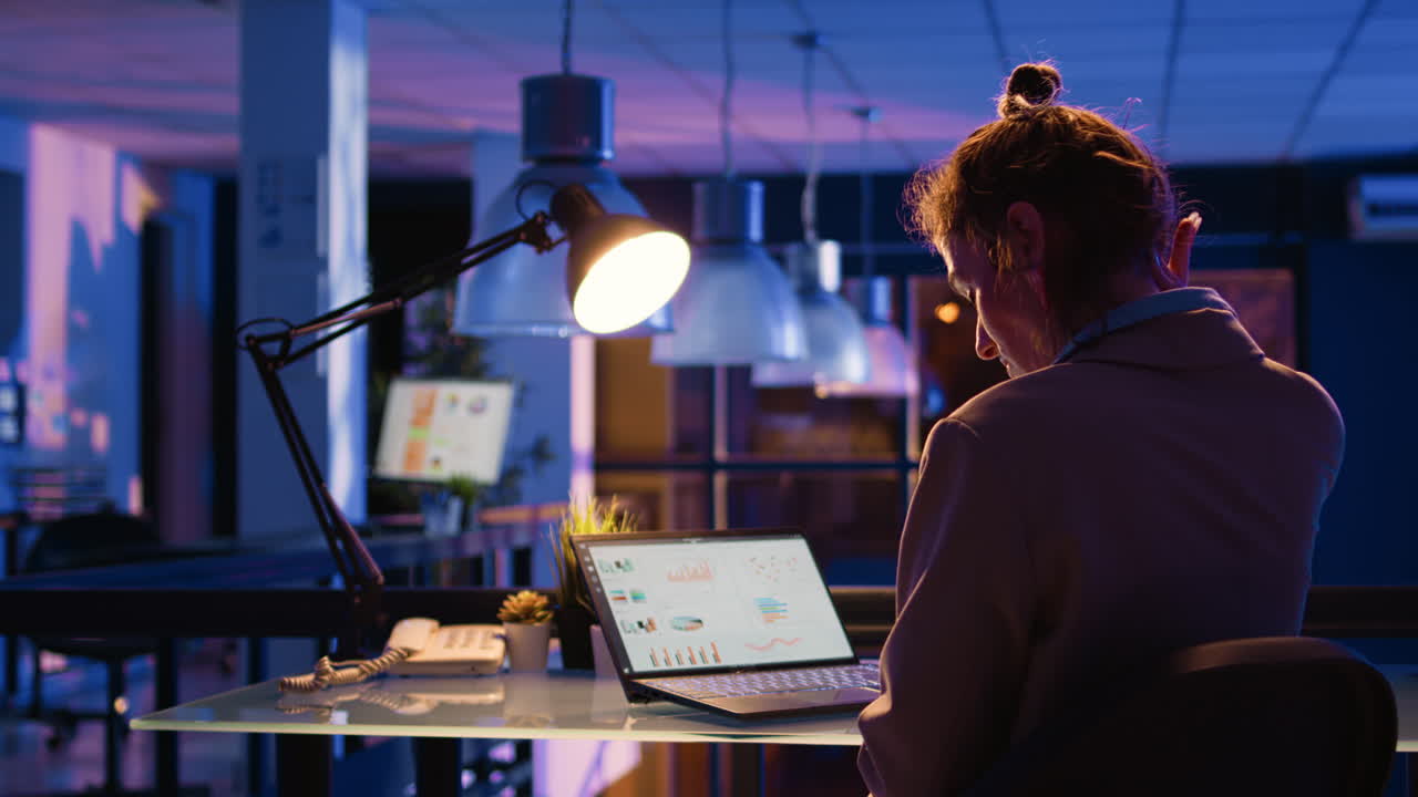 사무실에서 늦은 밤까지 일하는 여자