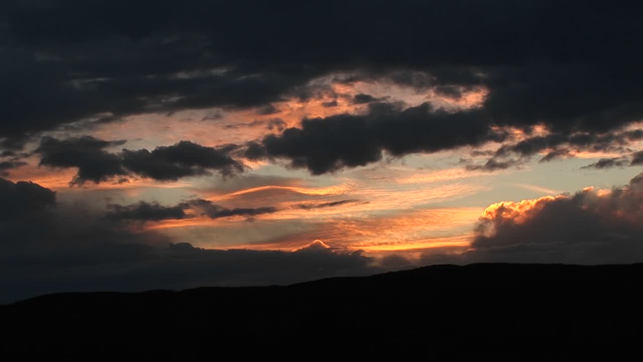 황금빛 하늘을 가로지르는 폭풍우 구름의 롱샷