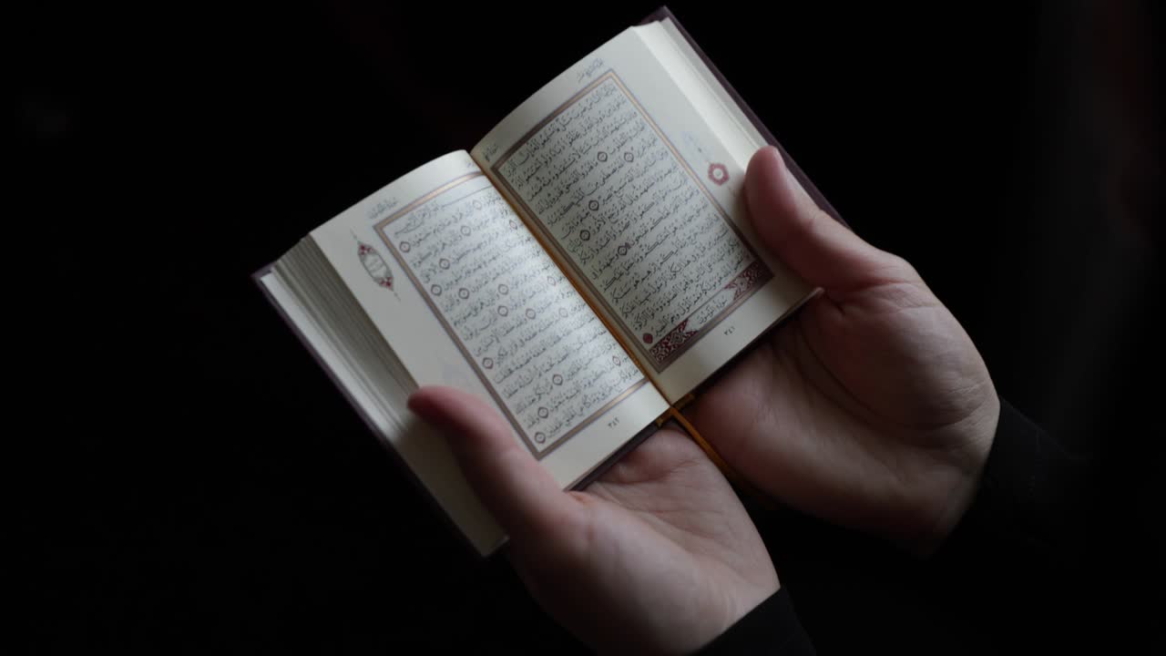 un tiro que se acerca a un corán y una mujer musulmana en hijab sosteniendo y leyendo el perfil plano