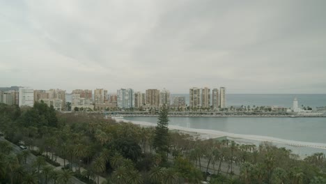 Calm-view-over-Malaga-harbor-and-lighthouse-with-overcast-gray-sky,-static-shot